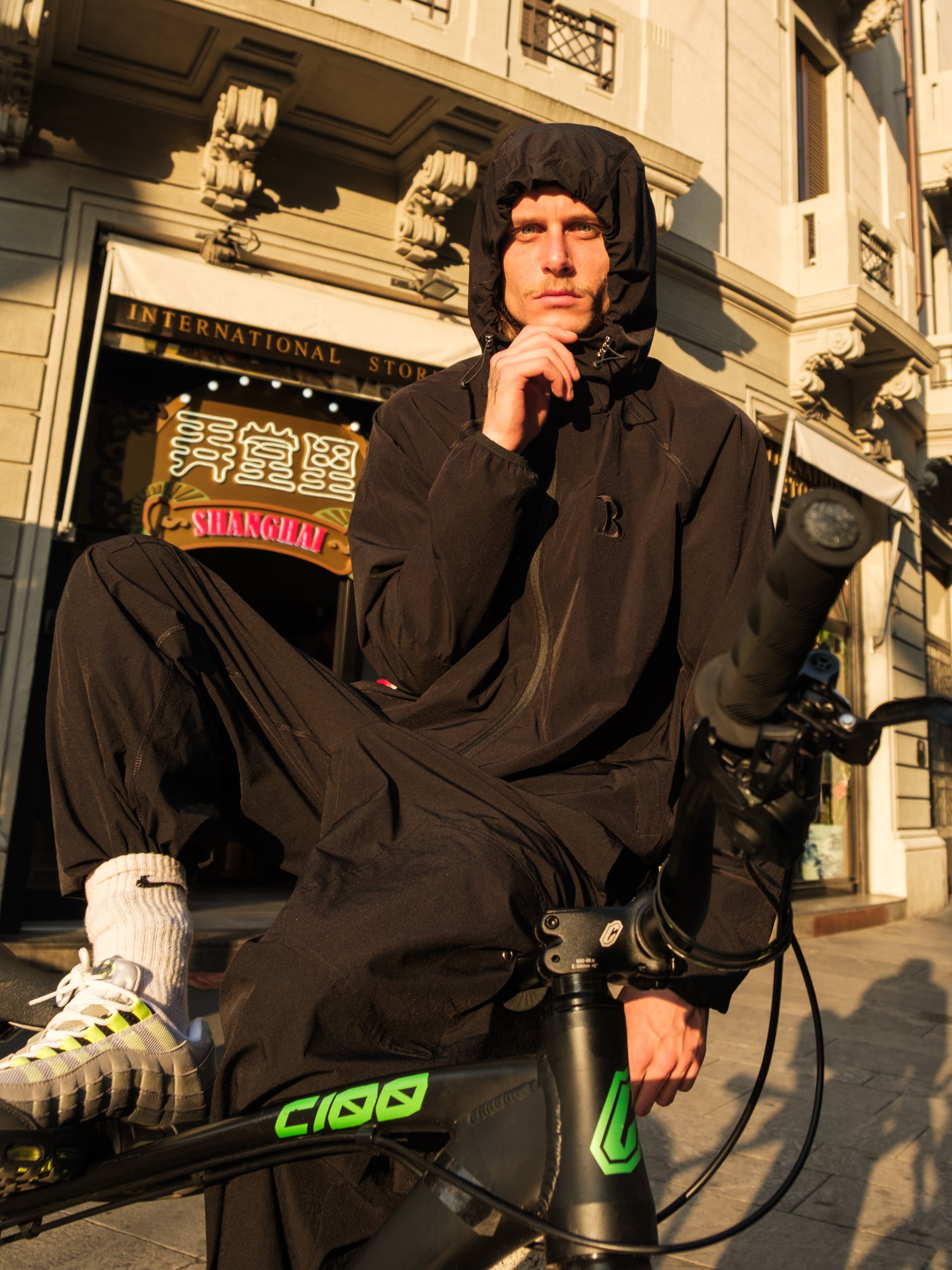 Bruno in Baggys Vanta Tracksuit sitting on a bike in Chinatown Milan