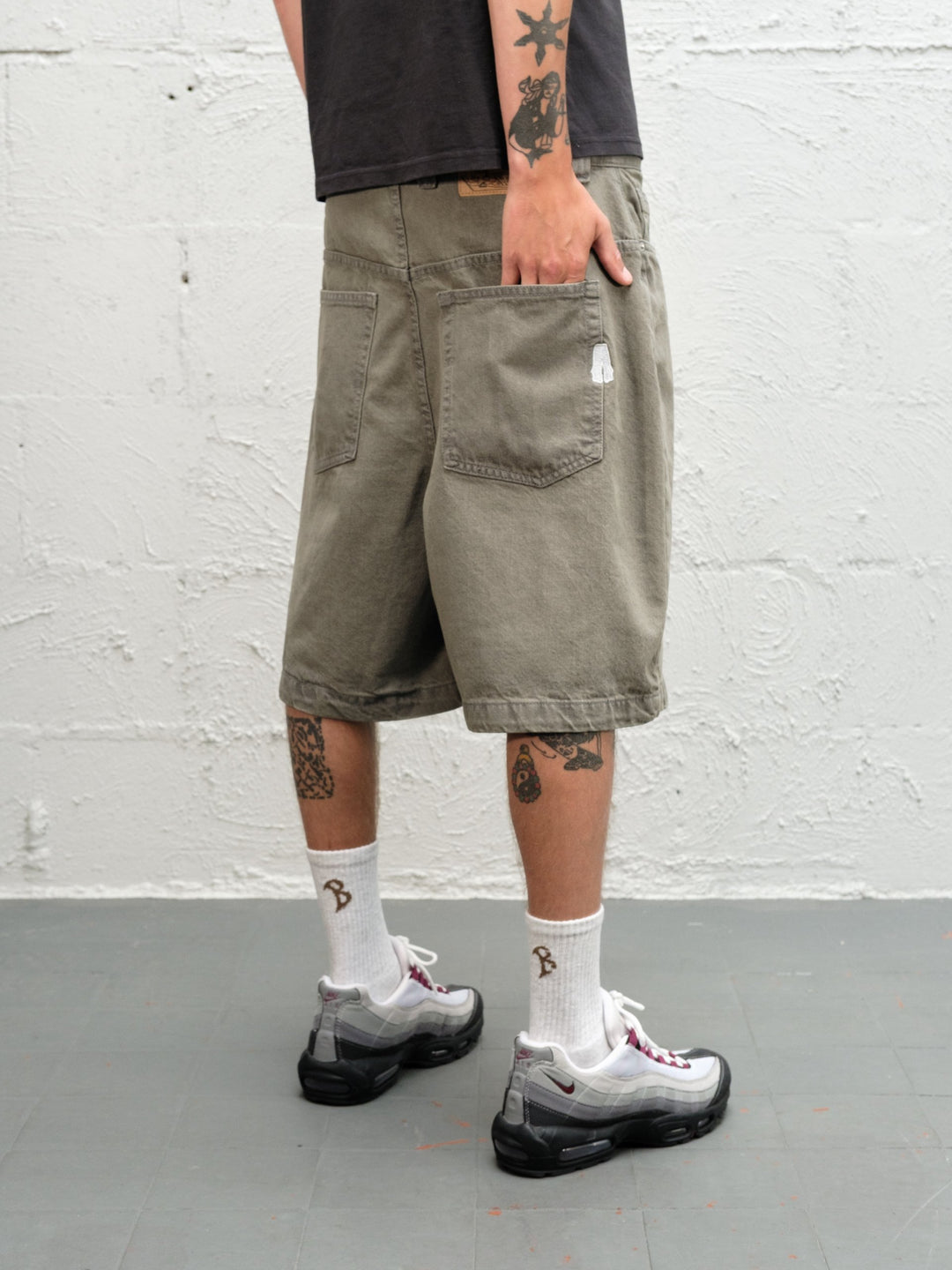 Model wearing Grab Tee faded black with Denim Short | Sage Baggys.uk close up of rear