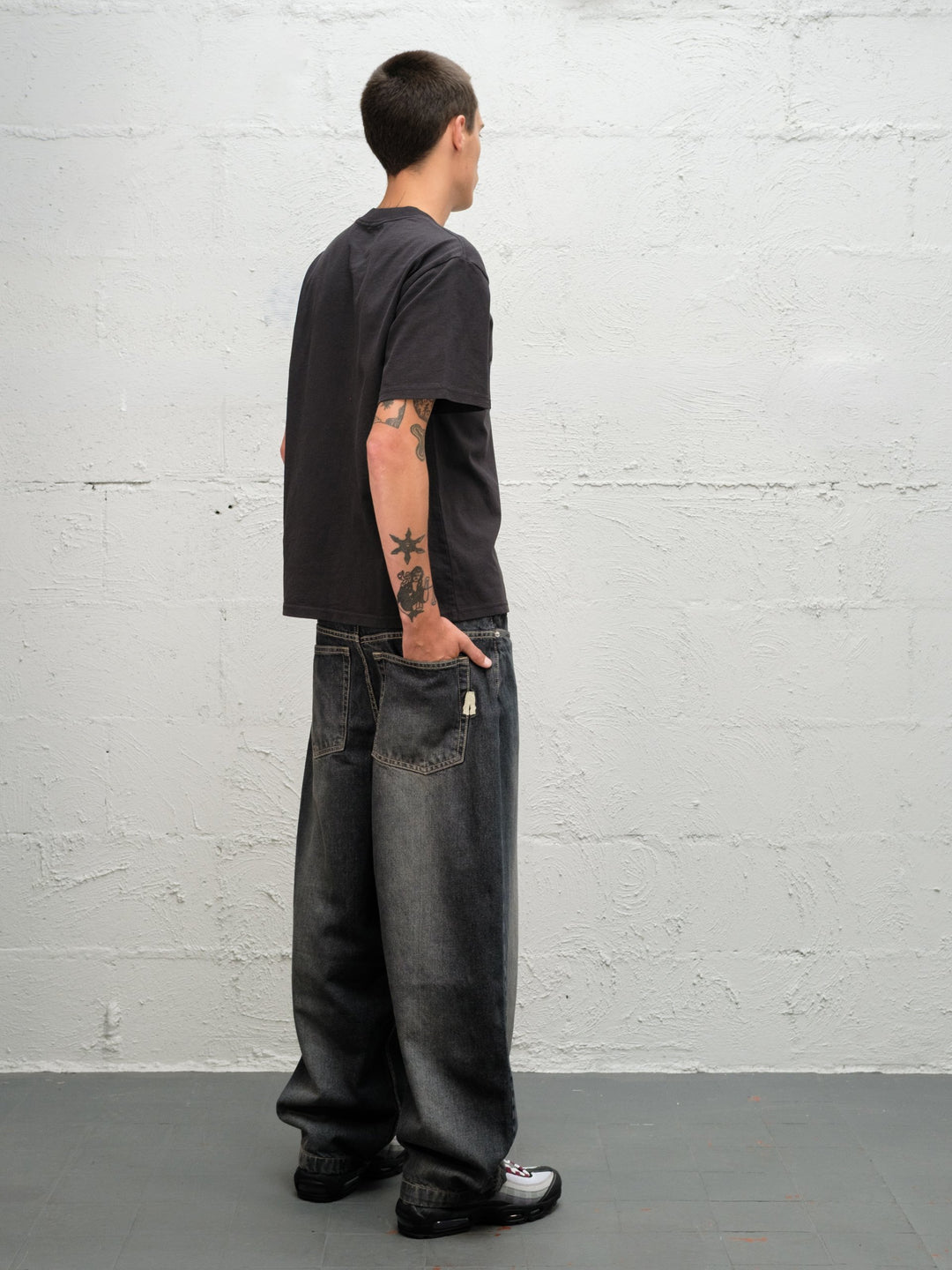 Model wearing grab tee with Denim Pant | Flint full rear side view