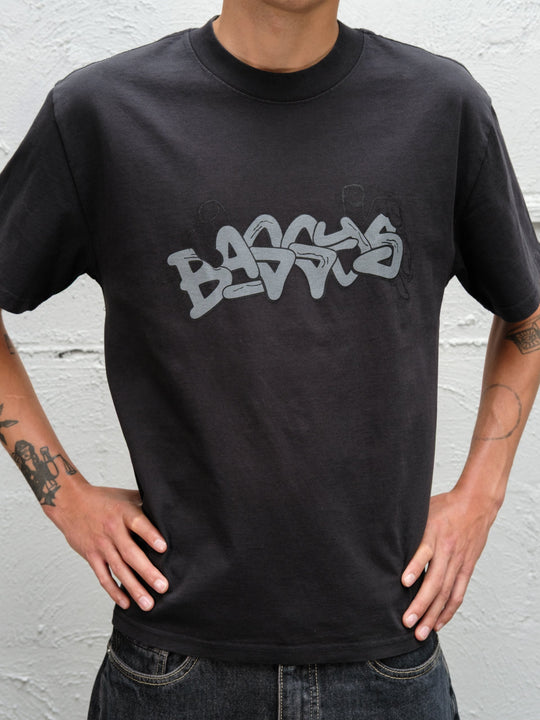 Model wearing Baggys Grab Tee in Faded Black, close up on graphic