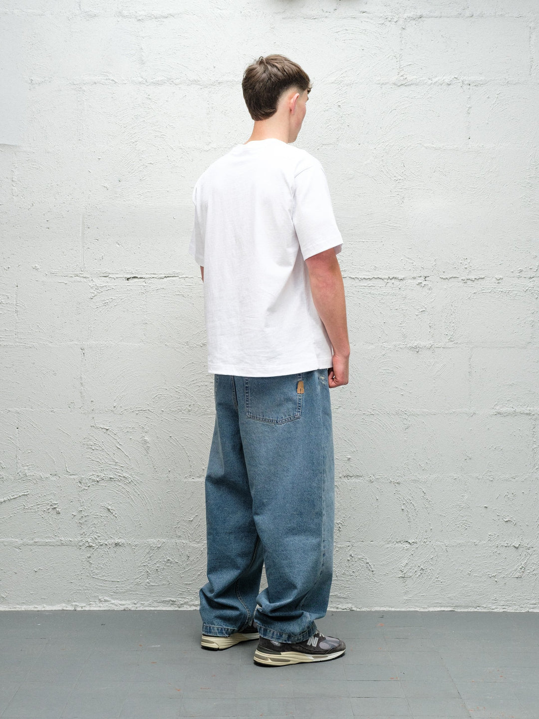 Model wearing Baggys Denim Pant Fray — light blue baggy jeans, rear view