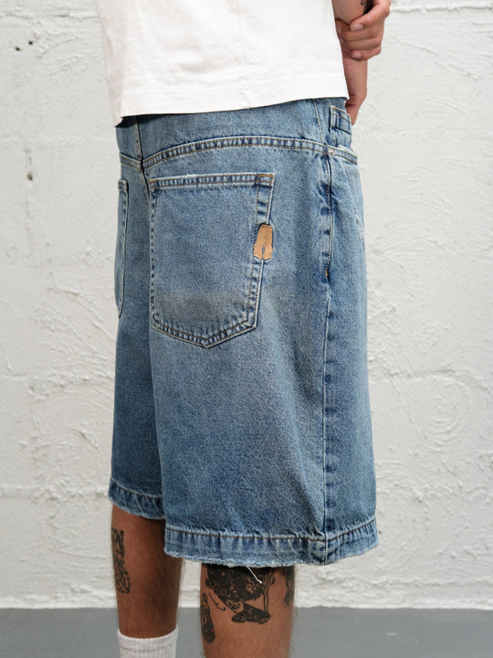 Model wearin Denim Short | Fray paired with 95's and a white t-shirt close up rear