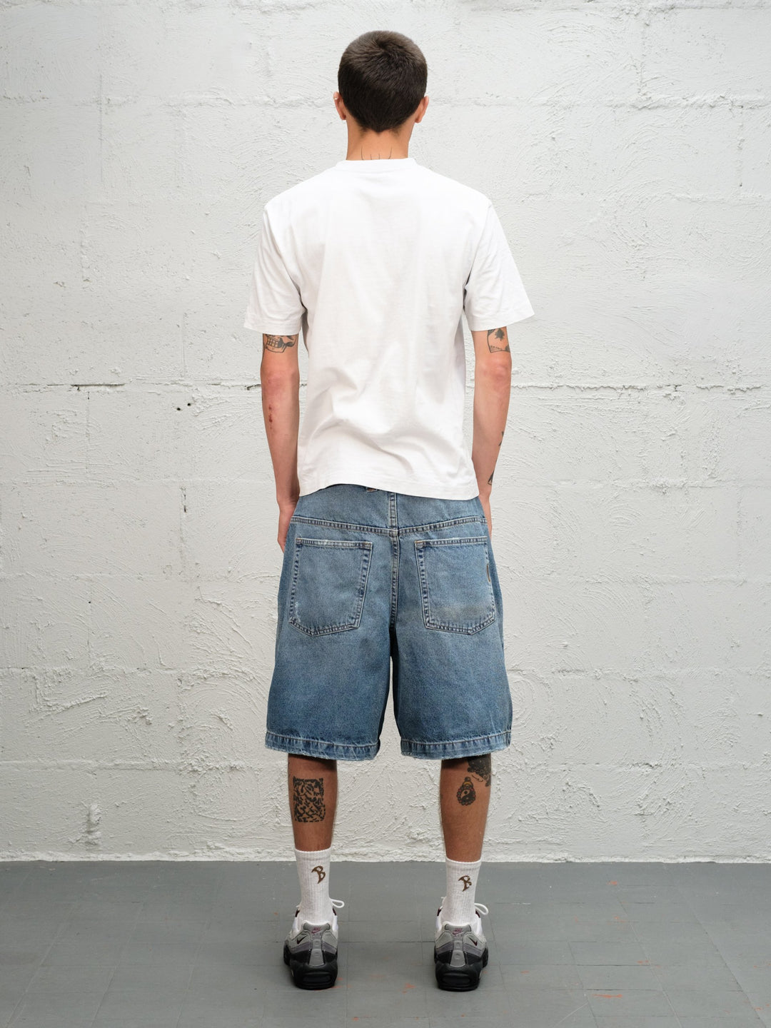 Model wearin Denim Short | Fray paired with 95's and a white t-shirt full rear view