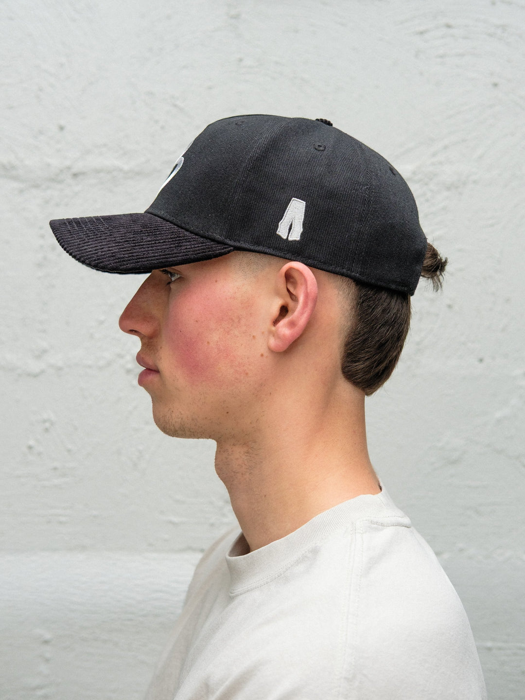 Person wearing Baggys 5-panel hat in black side profile