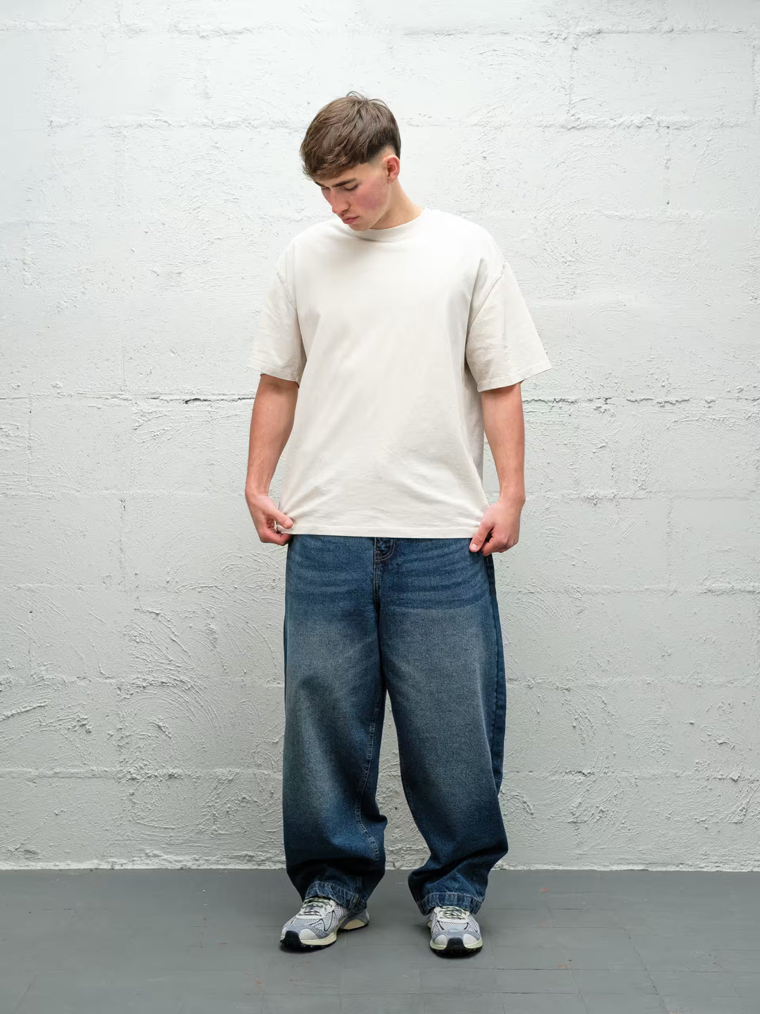 Person wearing black baggy denim frost jeans, made by Baggys.uk
