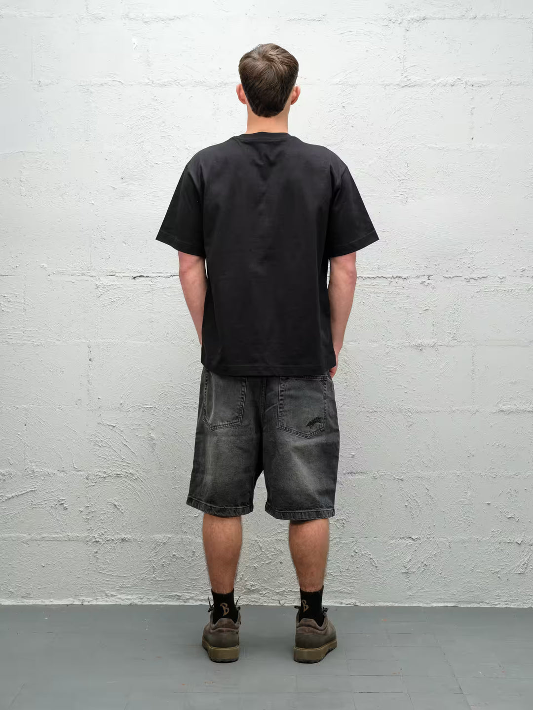 Person wearing black baggy denim fade jean shorts, made by Baggys.uk