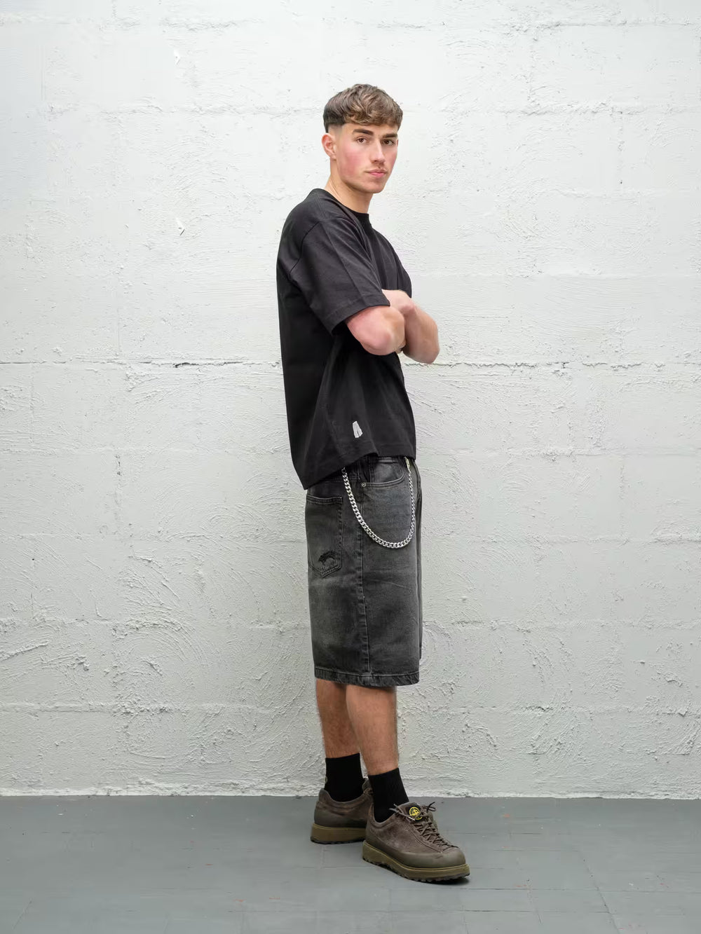 Person wearing black baggy denim fade jean shorts, made by Baggys.uk