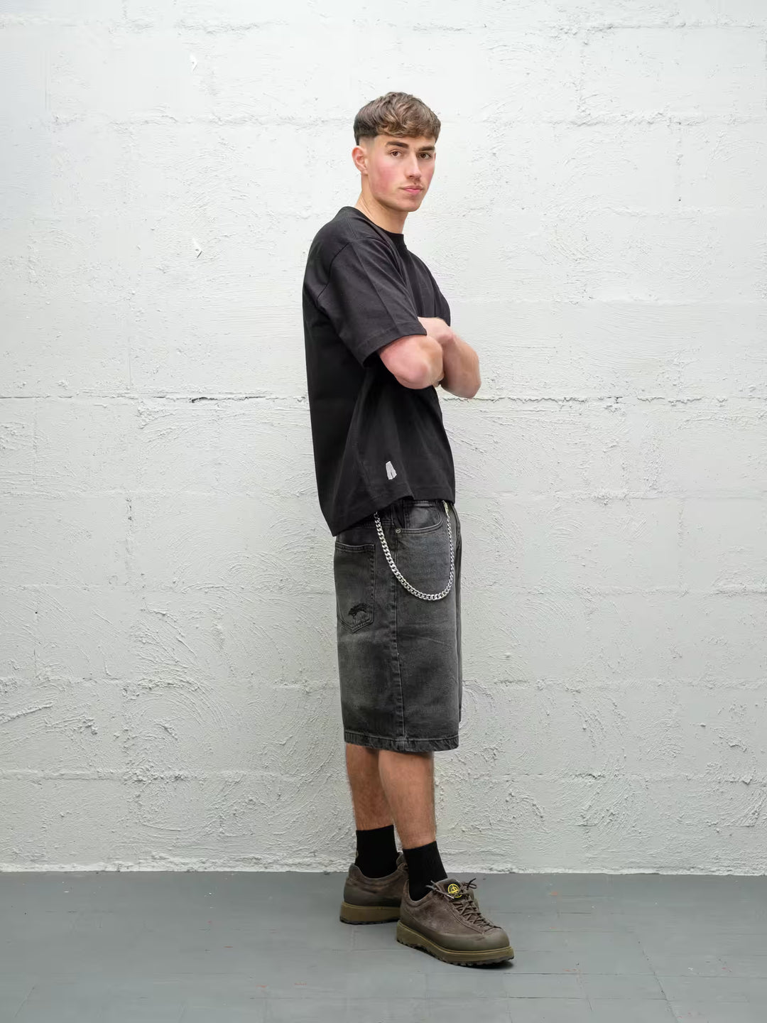 Person wearing black baggy denim fade jean shorts, made by Baggys.uk