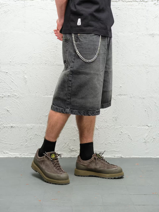 Person wearing black fade baggy denim shorts with the wallet chain