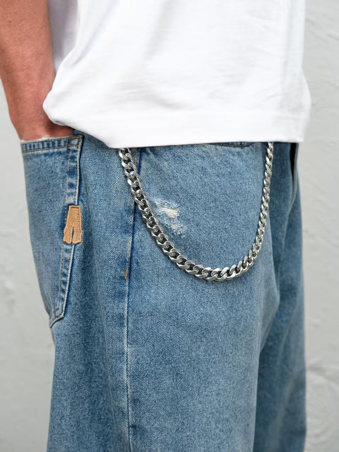 Person wearing Fray blue baggy denim pants with the wallet chain