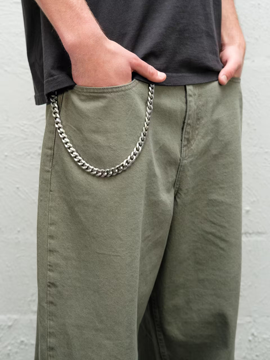 Person wearingSage green baggy denim pants with the wallet chain