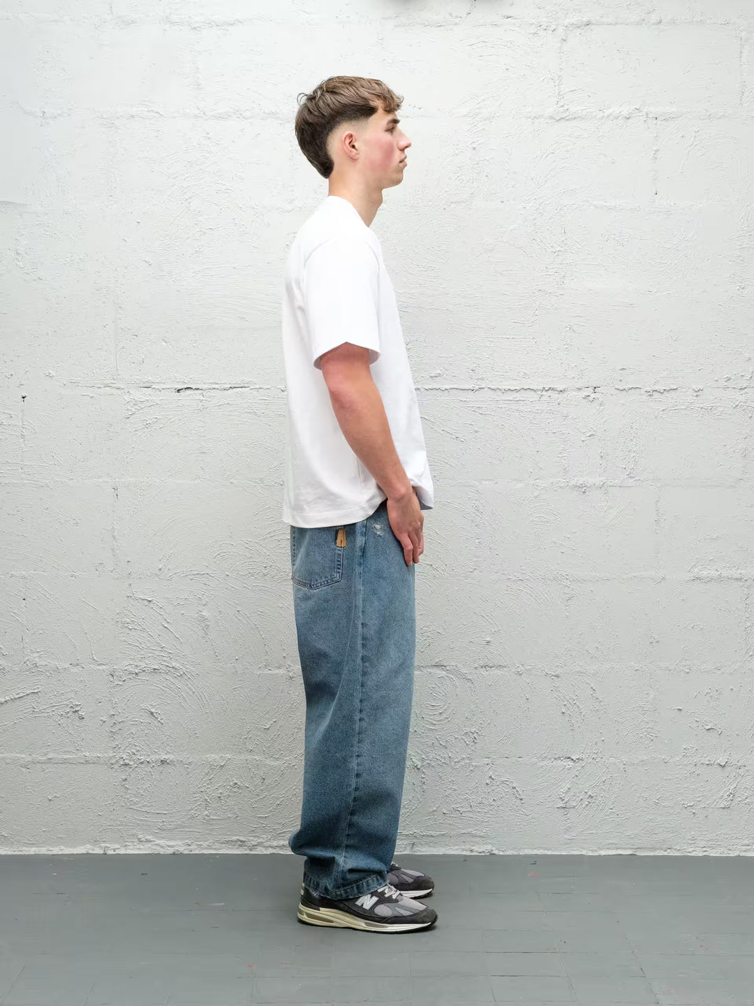 Model wearing Baggys Denim Pant Fray — light blue baggy jeans, side view