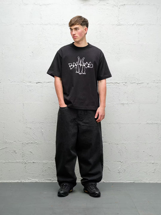 Person wearing black baggy denim pitch jeans, made by Baggys.uk