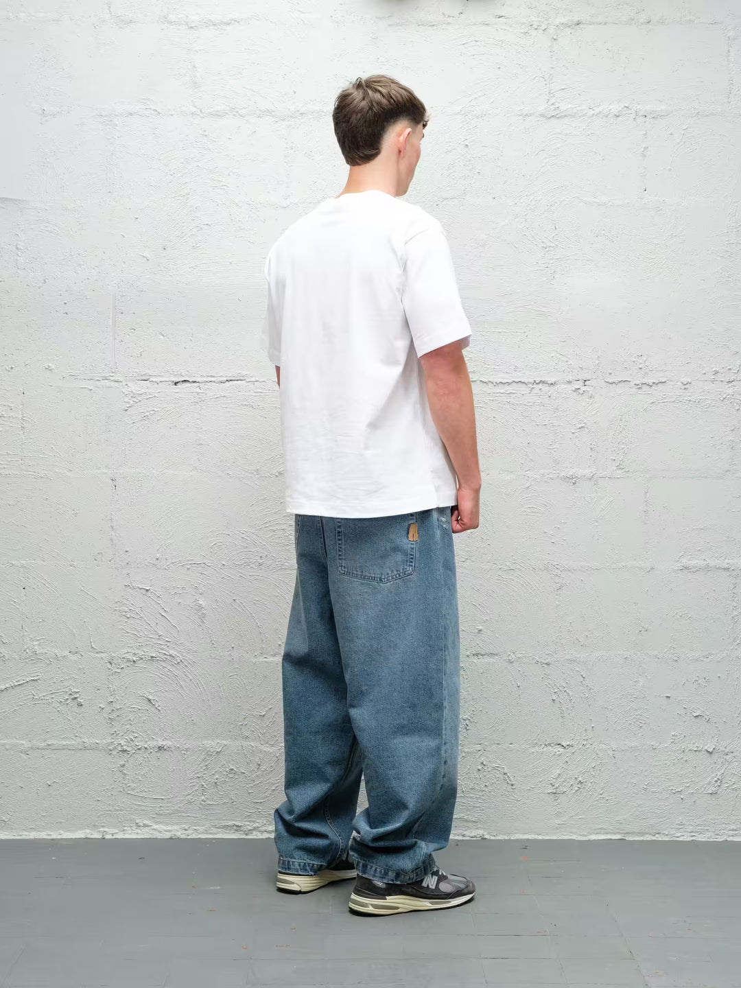Model wearing Baggys Denim Pant Fray — light blue baggy jeans, rear view