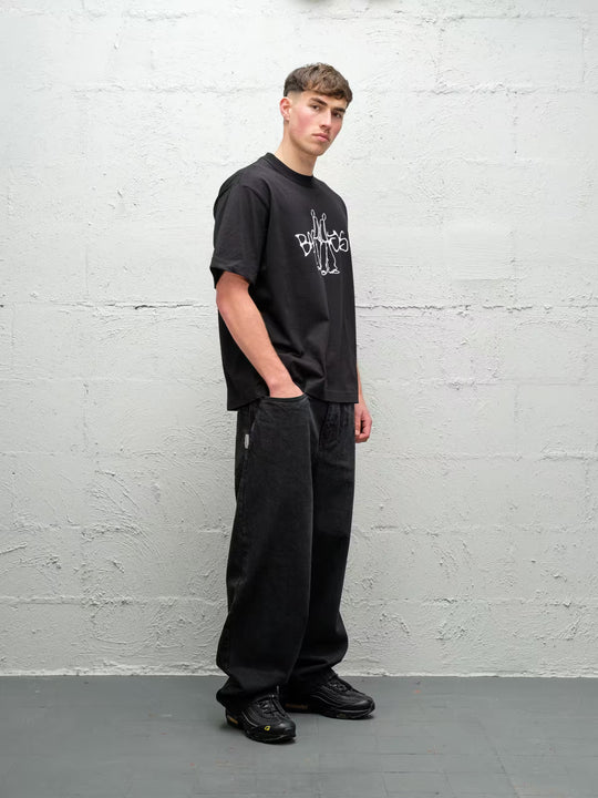Person wearing black baggy denim pitch jeans, made by Baggys.uk