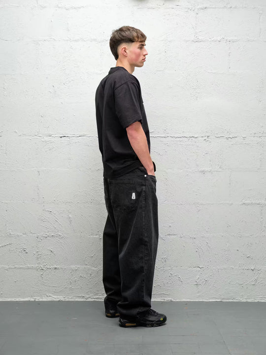 Person wearing black baggy denim pitch jeans, made by Baggys.uk