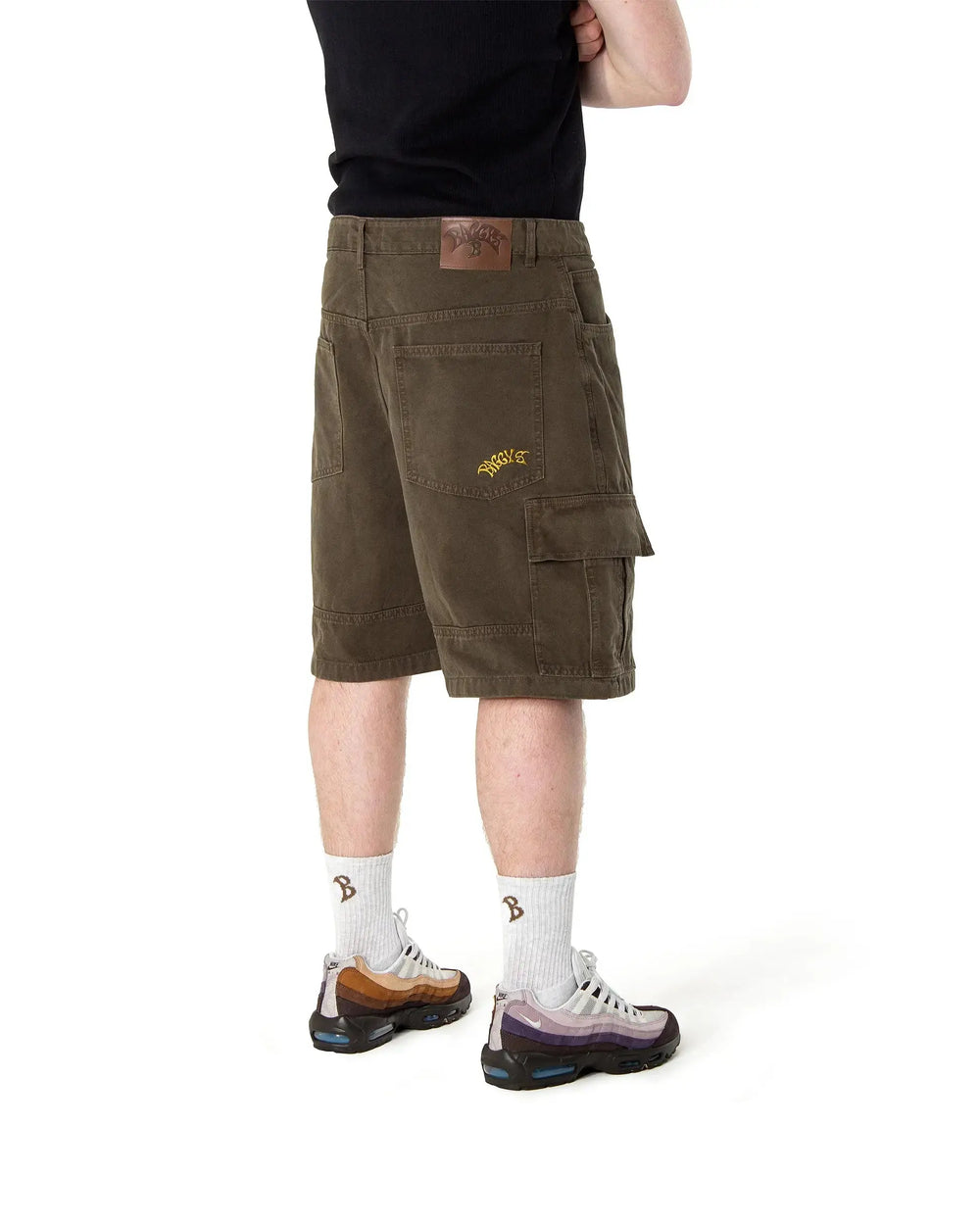 Person wearing brown cargo shorts on a white background