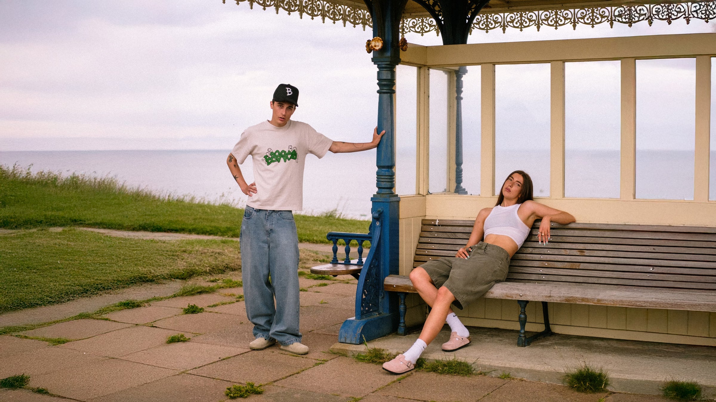 Models on the peer, with the sea behind them, wearing denim pant fray and denim short sage