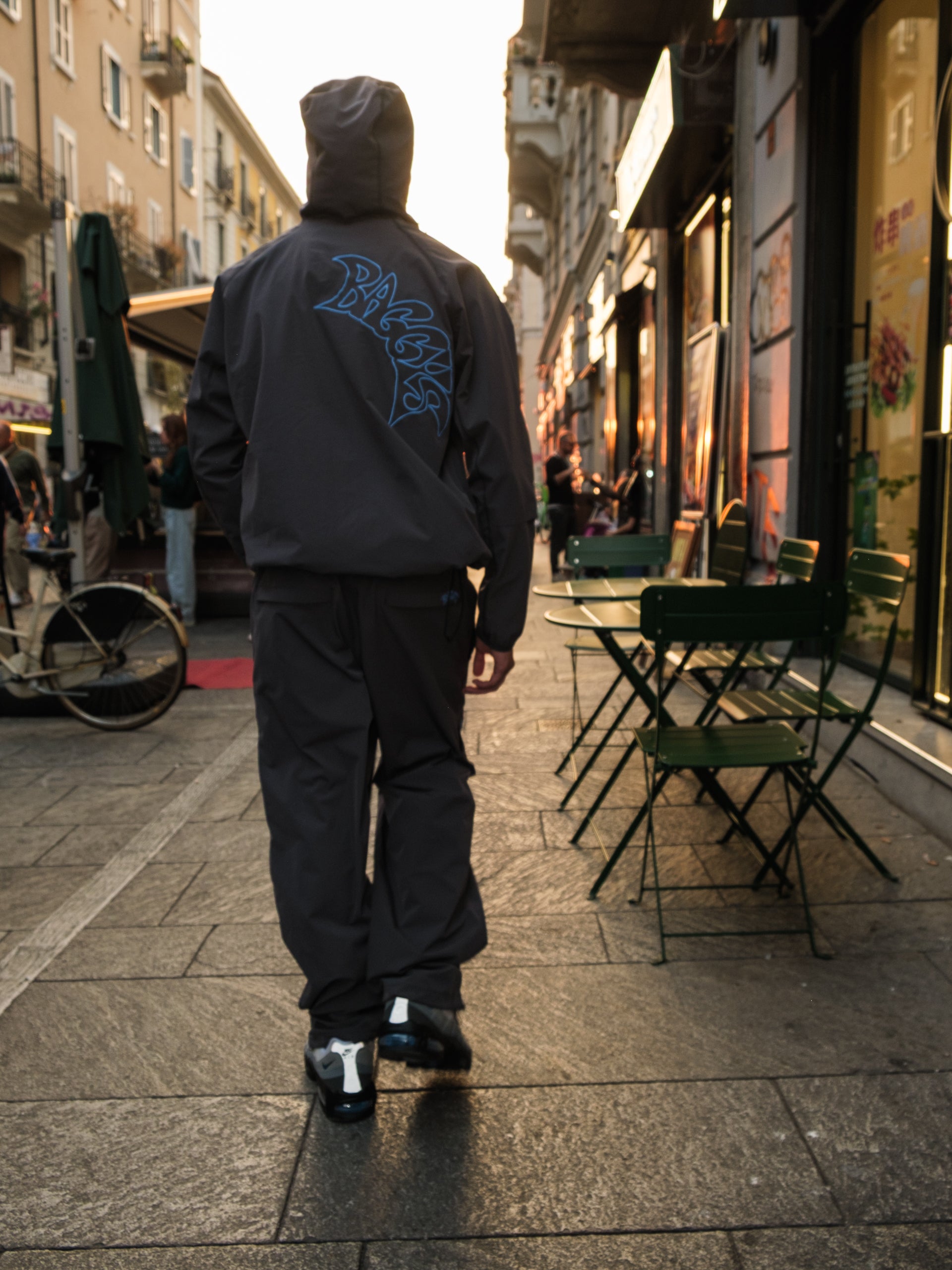 Person wearing the Baggys Oxide Grey Tracksuit  walking on a city street in Milan
