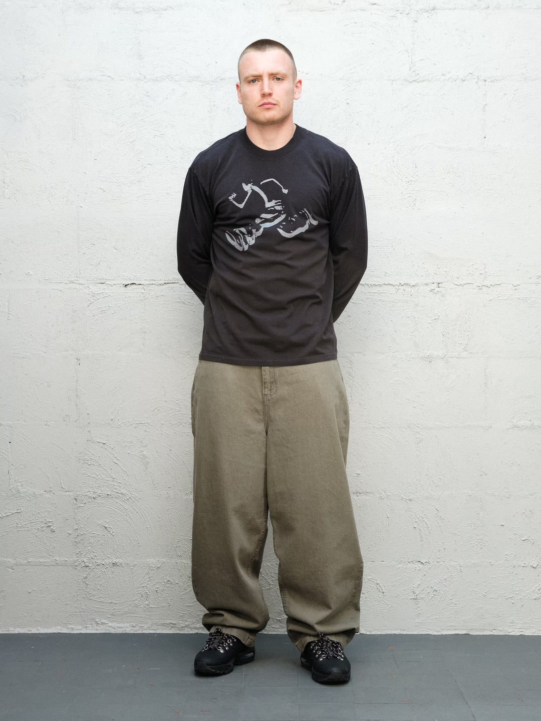 Model wearing Runnin man tee faded black with DENIM PANT | SAGE Baggys.uk