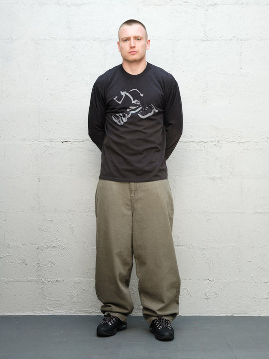 Model wearing Runnin man tee faded black with DENIM PANT | SAGE Baggys.uk