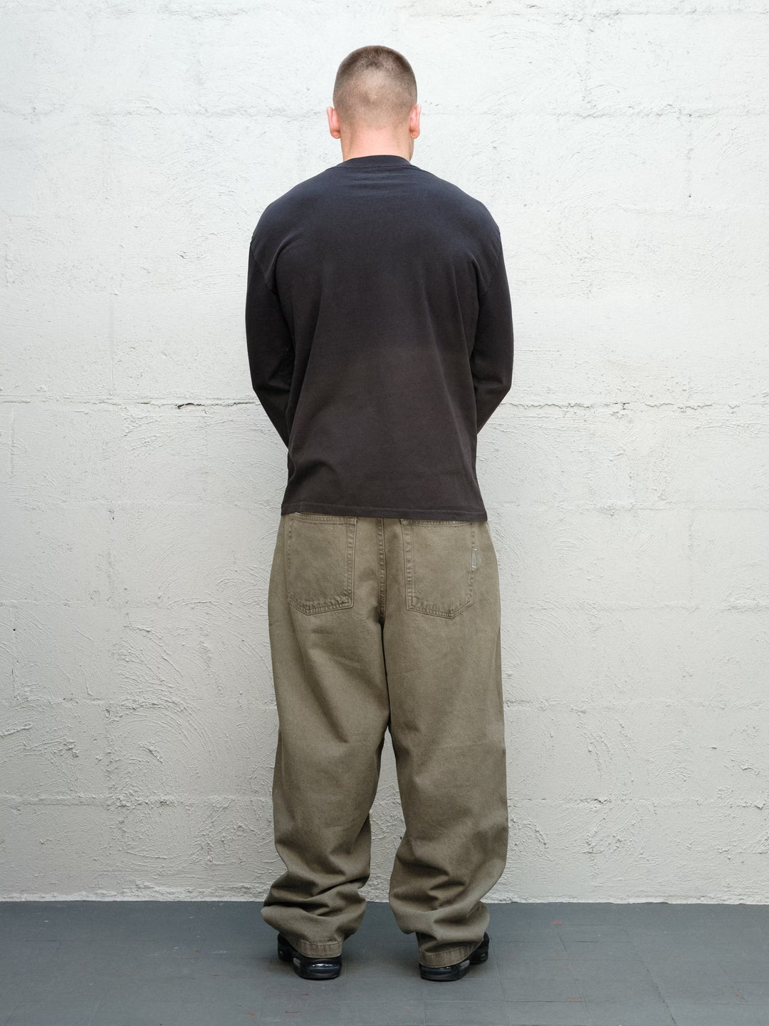 Model wearing Baggys Runnin' Man Tee in Faded Black, rear view