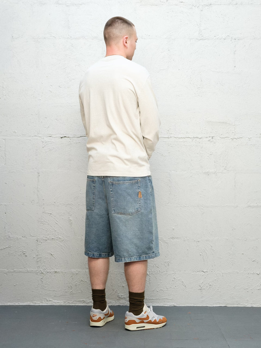 Model wearing Runnin' Man Tee in Bone and Denim Short | Fray 