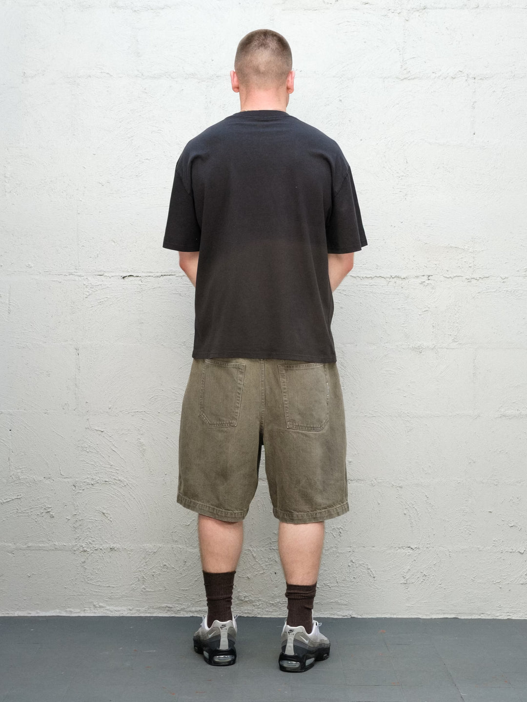 Model wearing Baggys Grab Tee in Faded Black, rear view