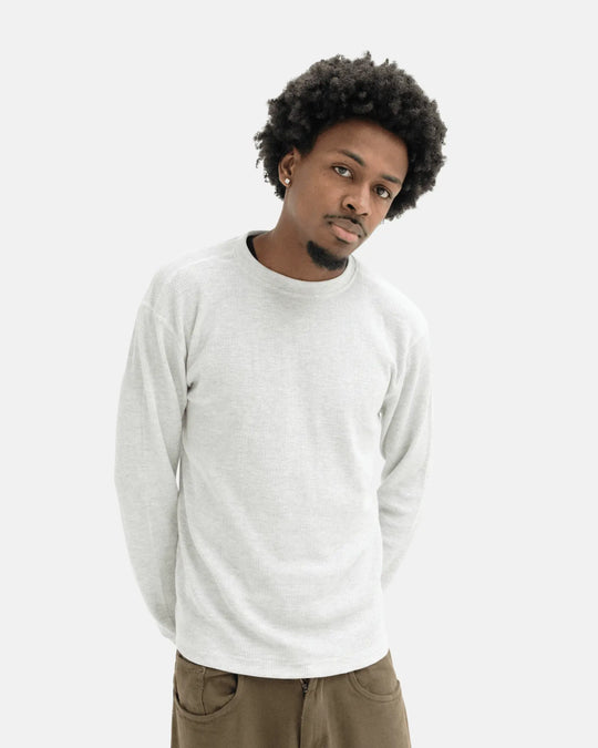 Man wearing a light gray long sleeve t-shirt on a white background