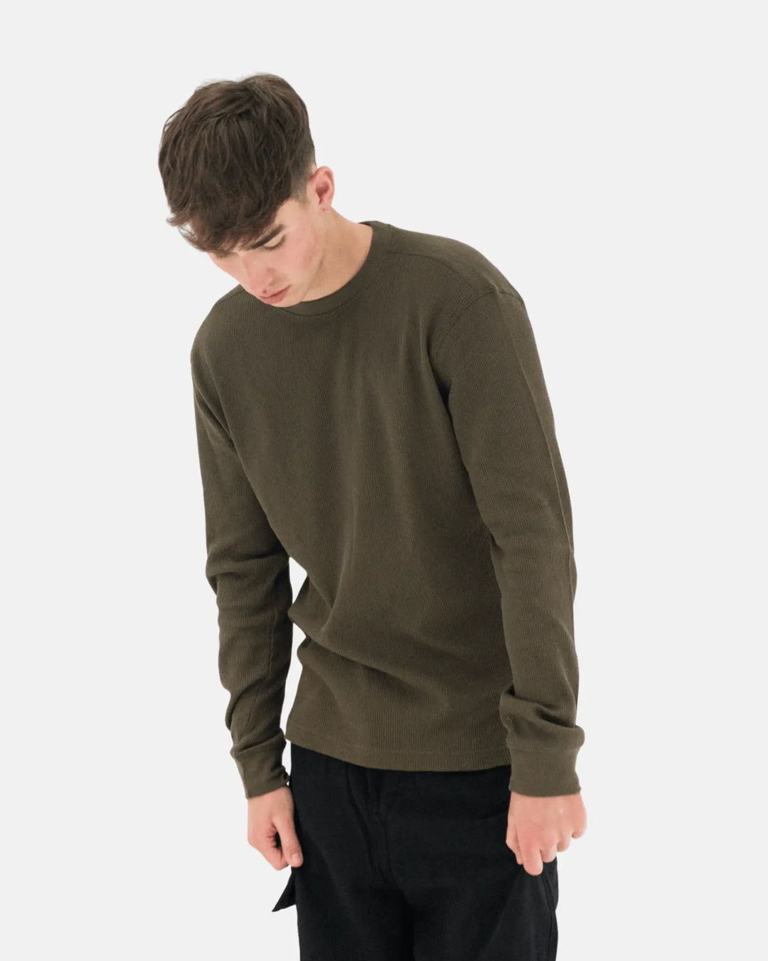 Person wearing an olive green long sleeve t-shirt on a white background