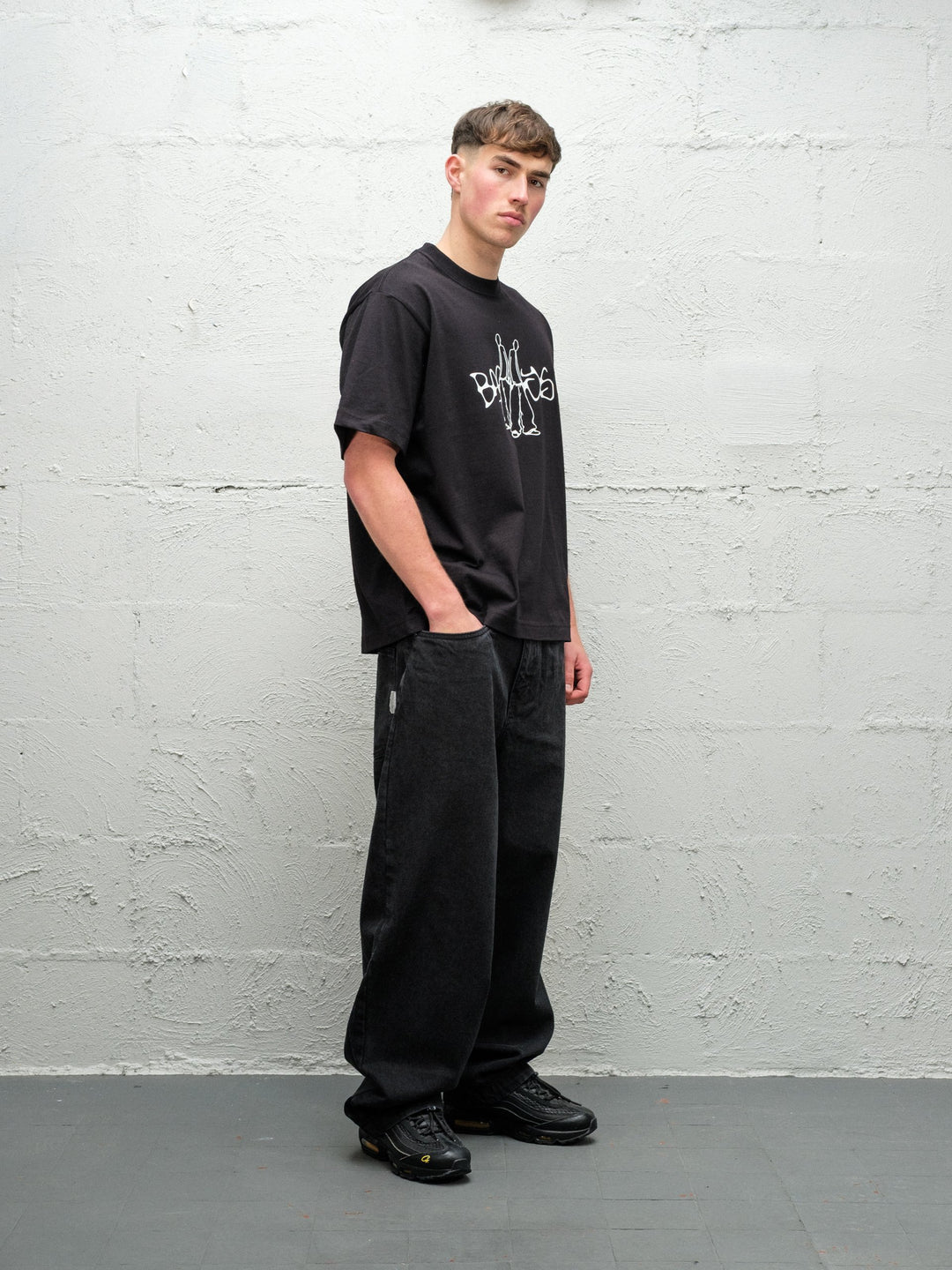 Person wearing black baggy denim pitch jeans, made by Baggys.uk