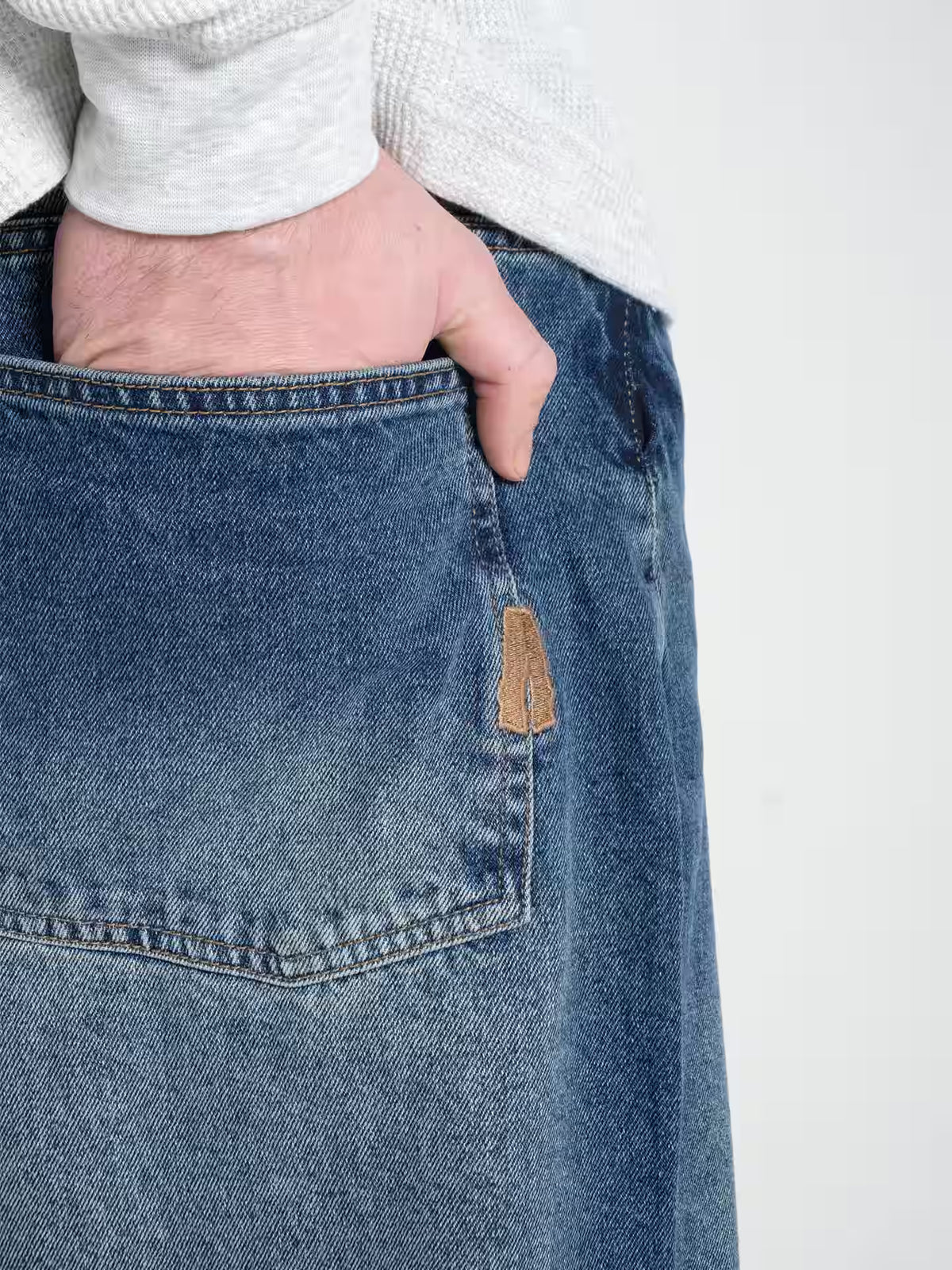 Person wearing Baggy Jeans Frost blue, showing the detailing of the back pocket embroidery 