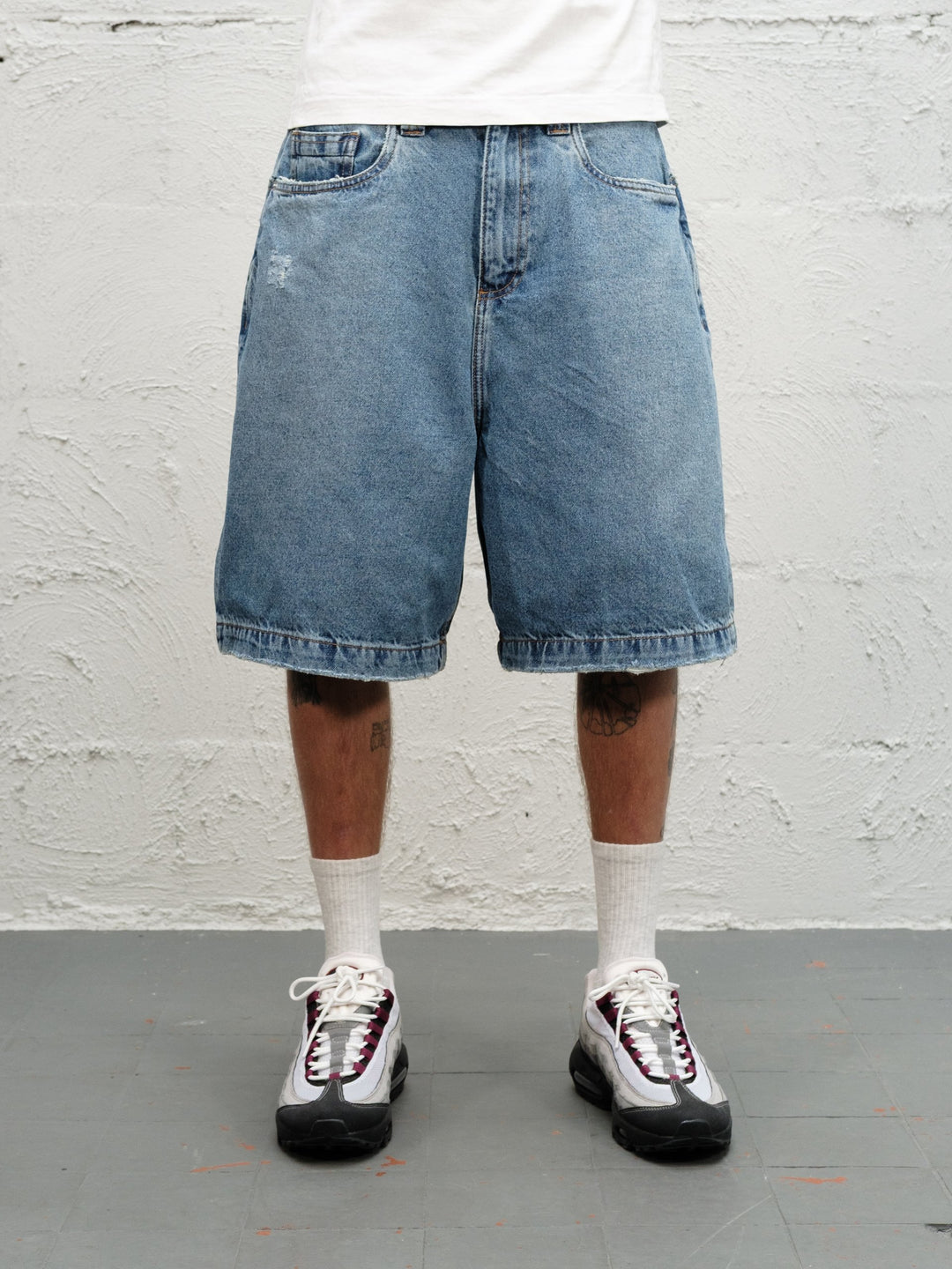 Model wearin Denim Short | Fray paired with 95's and a white tshirt close up on shorts