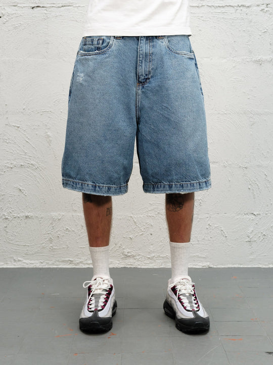 Model wearin Denim Short | Fray paired with 95's and a white tshirt close up on shorts