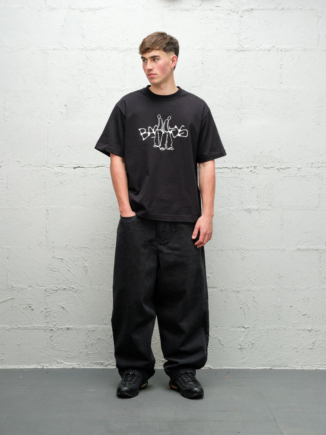 Person wearing black baggy denim pitch jeans, made by Baggys.uk