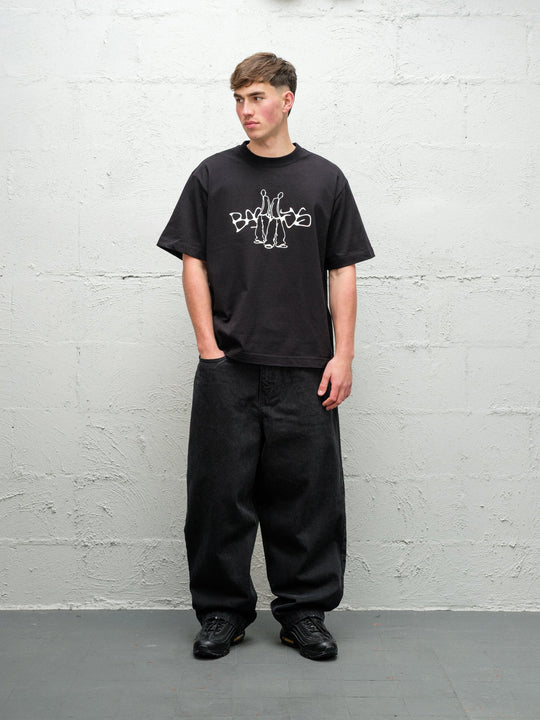 Person wearing black baggy denim pitch jeans, made by Baggys.uk