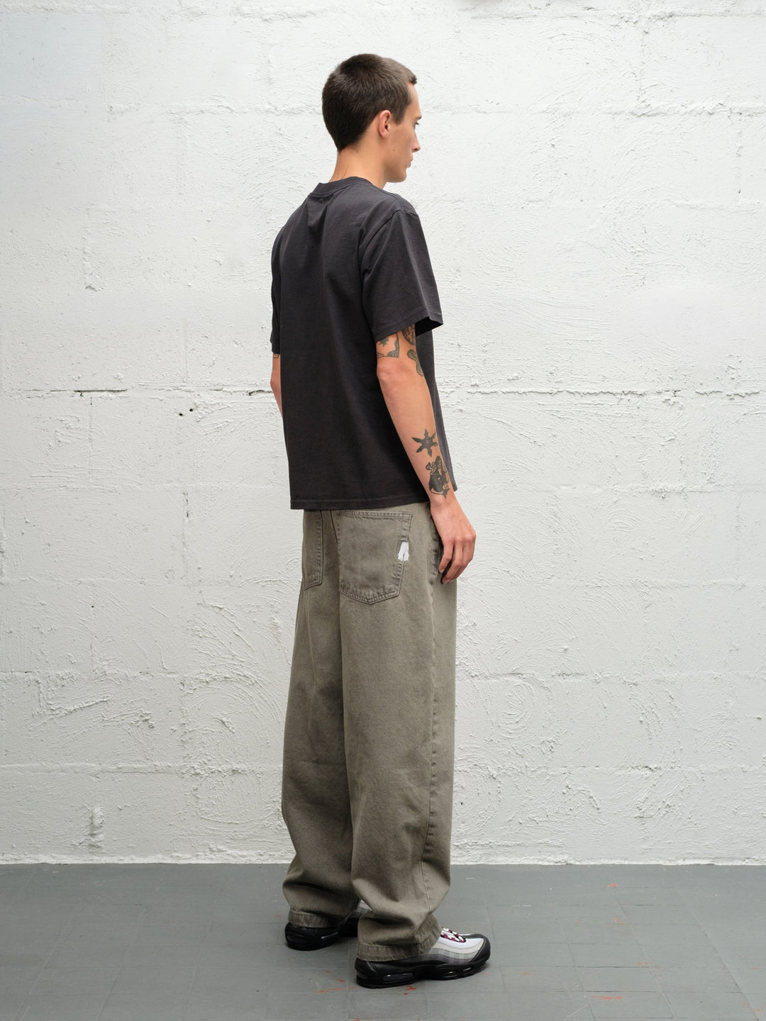 Model wearing Grab tee faded black with DENIM PANT | SAGE rear view