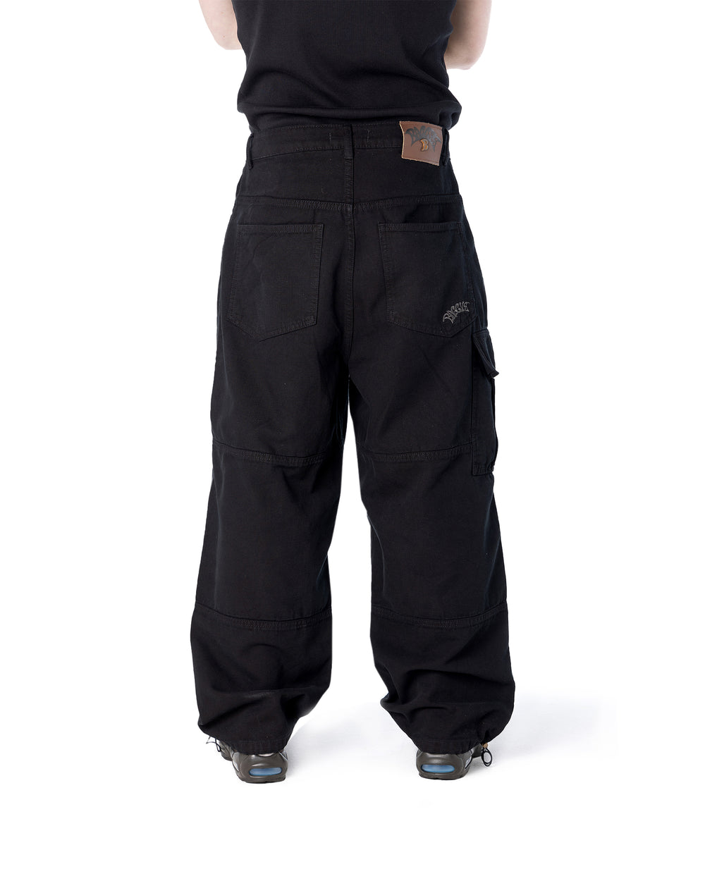 Black cargo pants worn by a person on a white background
