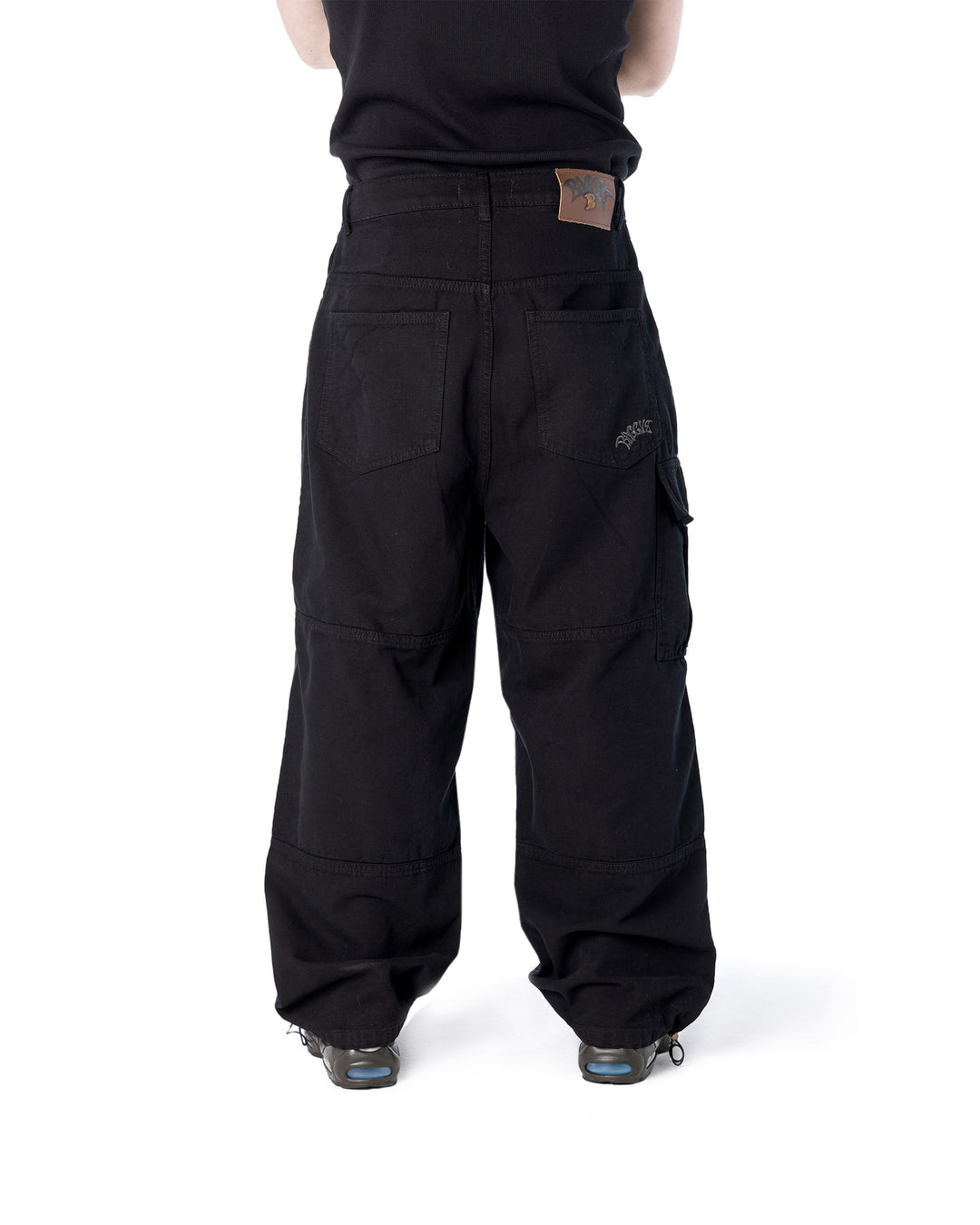 Black cargo pants worn by a person on a white background