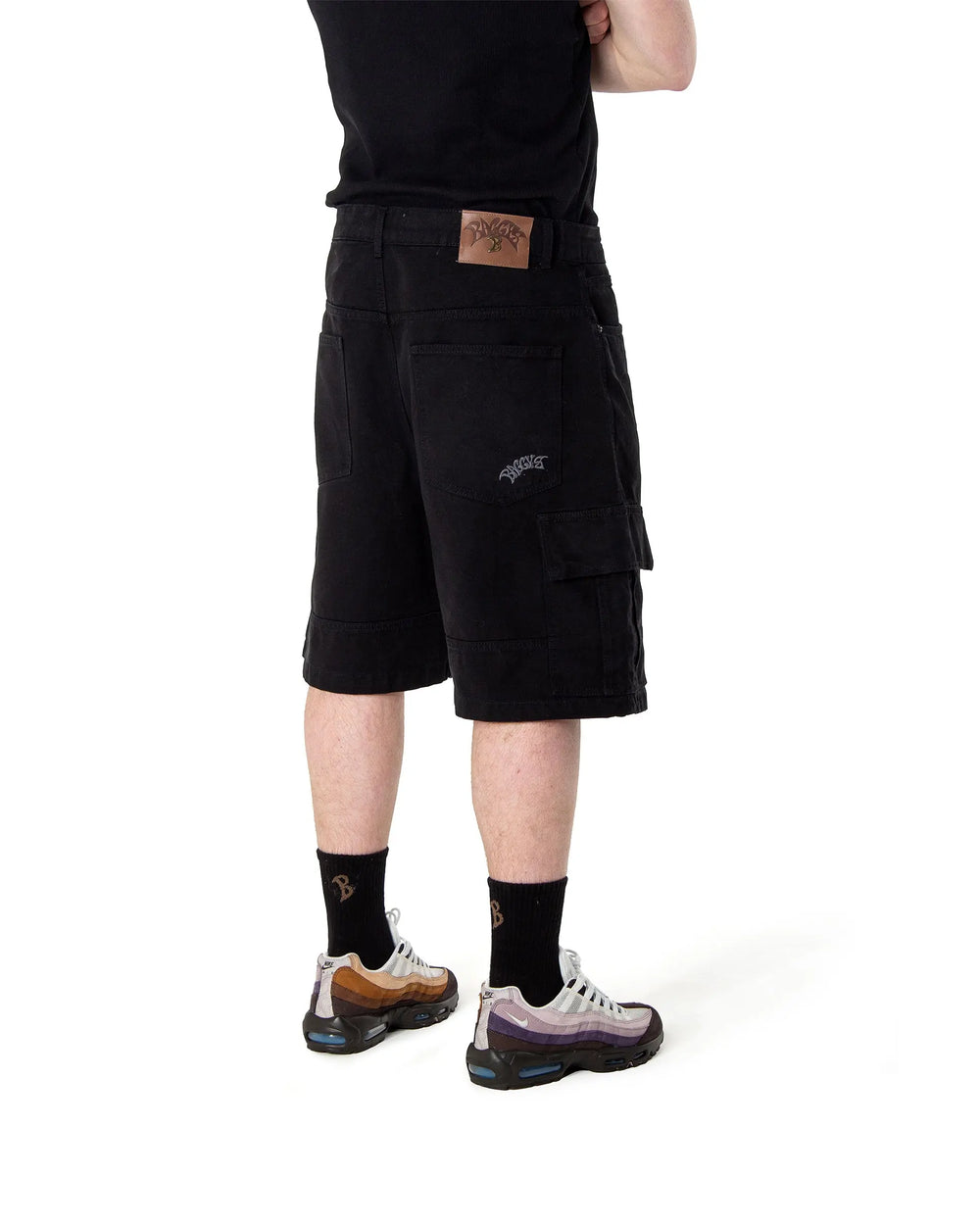 Person wearing black cargo shorts on a white background