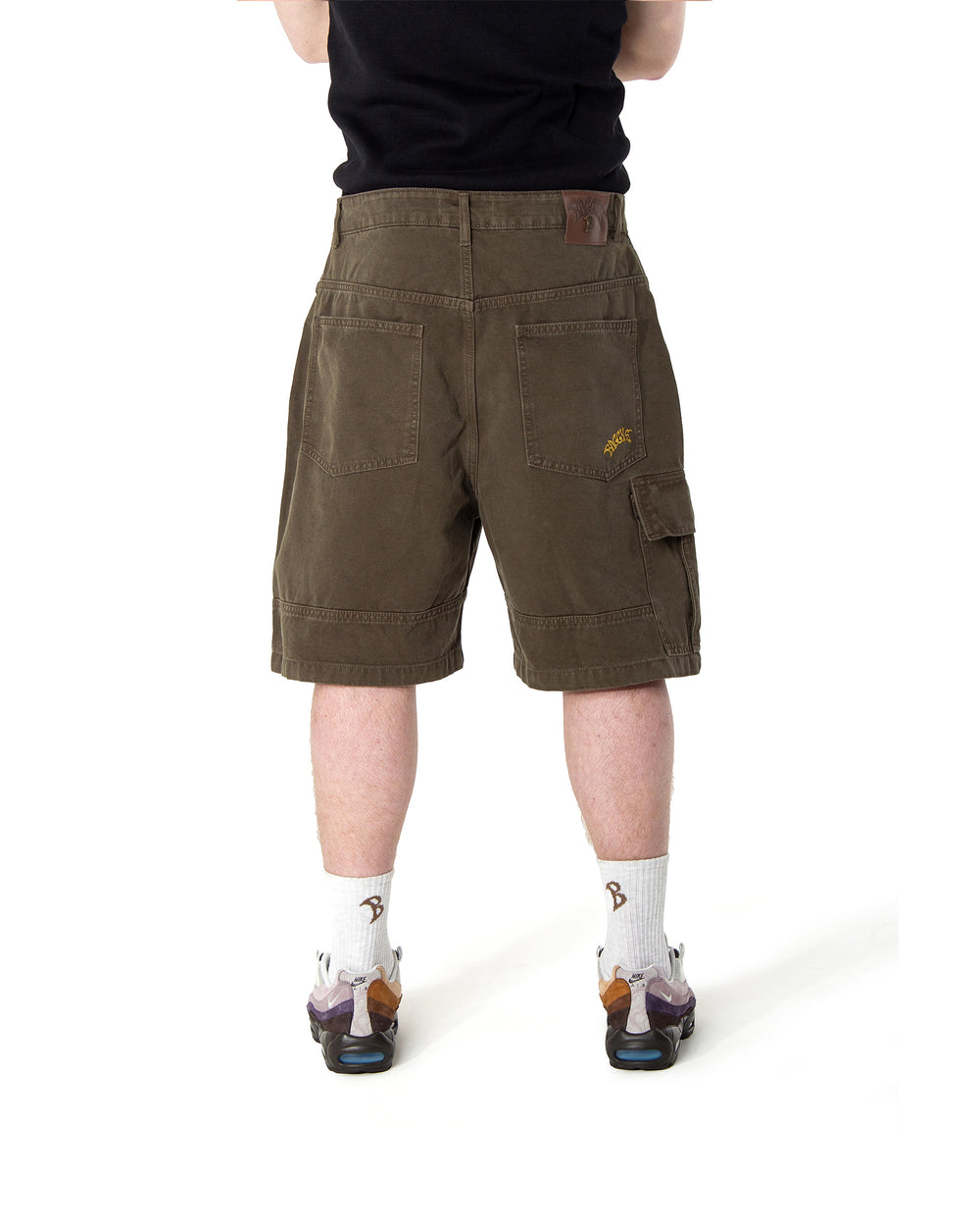 Person wearing brown cargo shorts on a white background