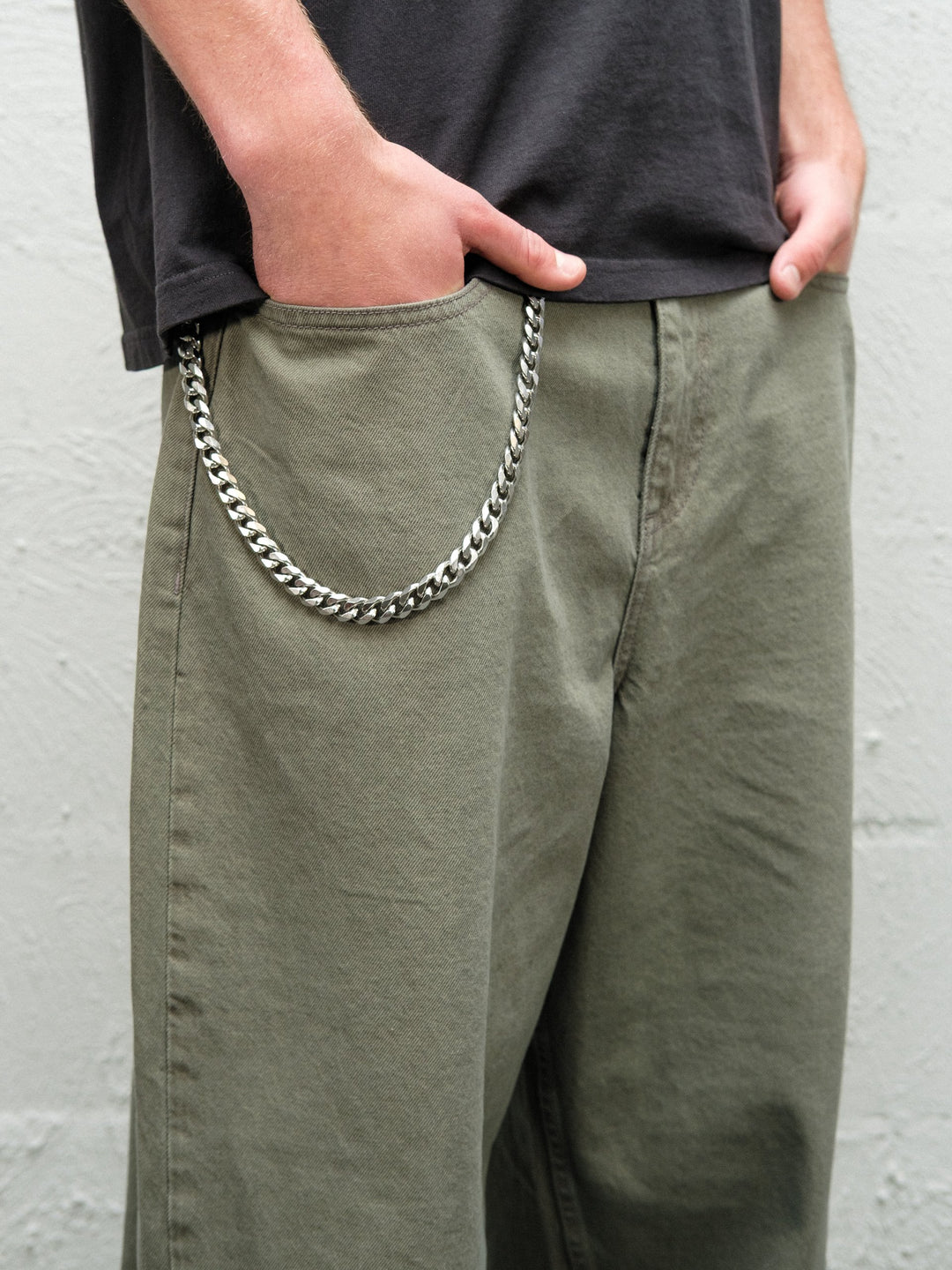 Person wearingSage green baggy denim pants with the wallet chain