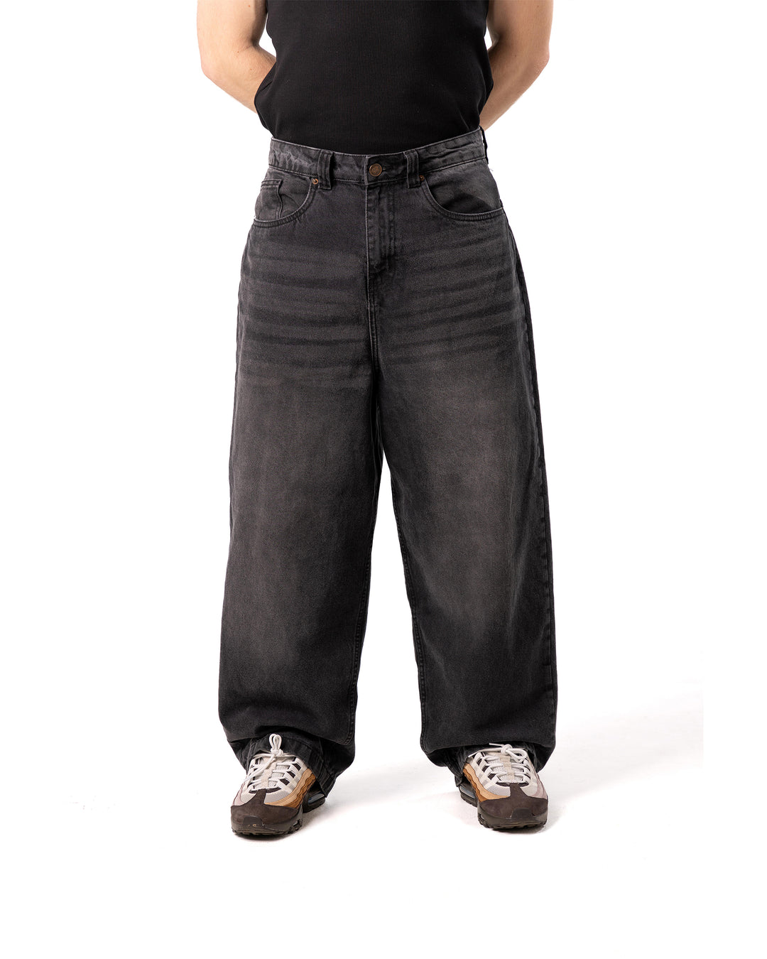 Person wearing wide-leg black jeans on a white background