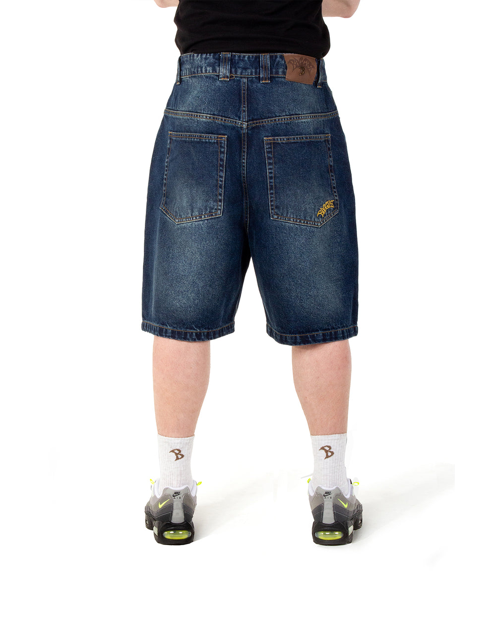 Person wearing blue denim shorts on a white background