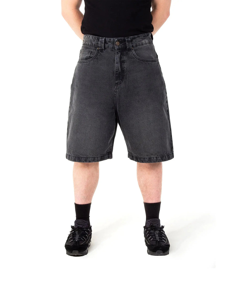 Person wearing black denim shorts on a white background