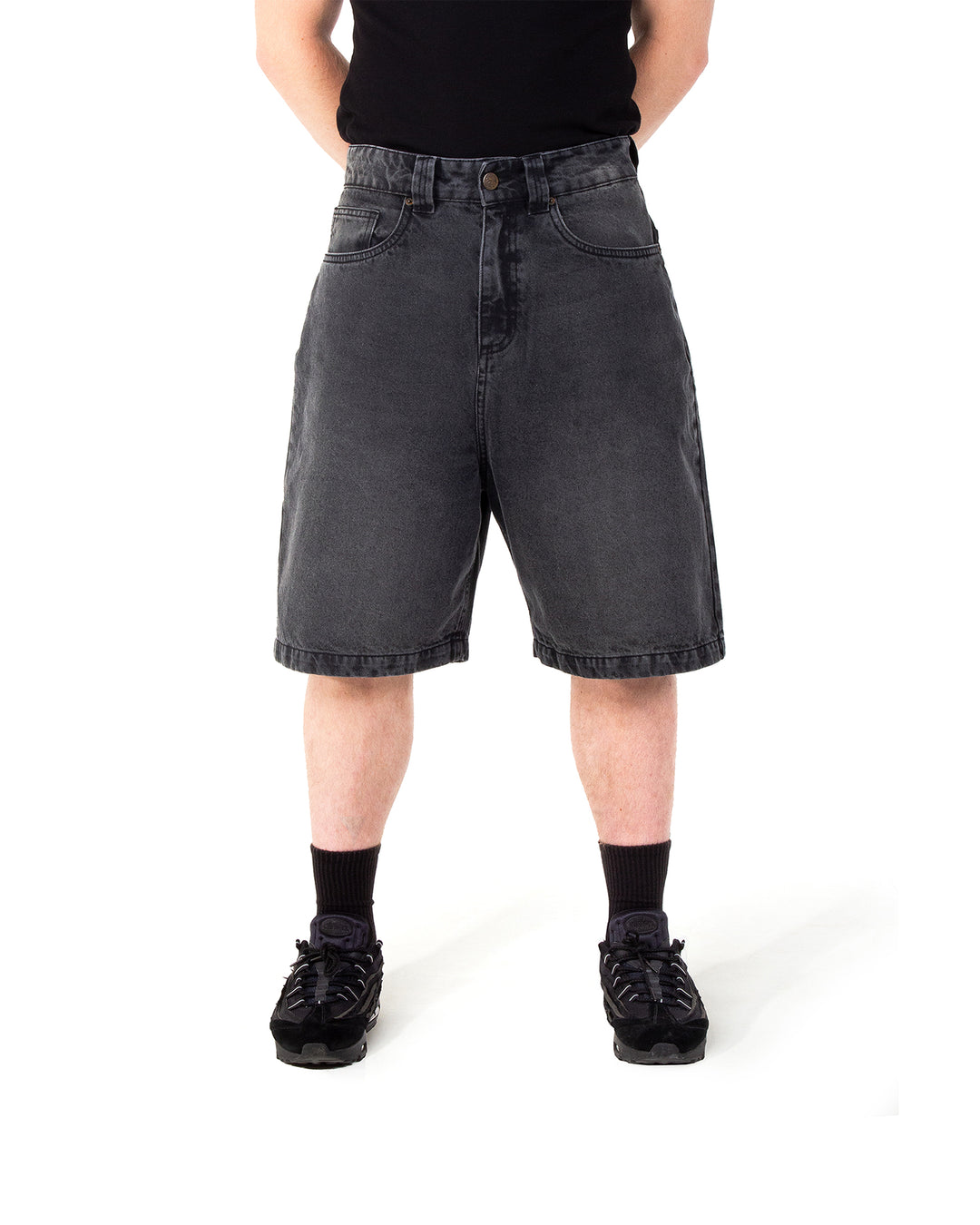 Person wearing black denim shorts on a white background