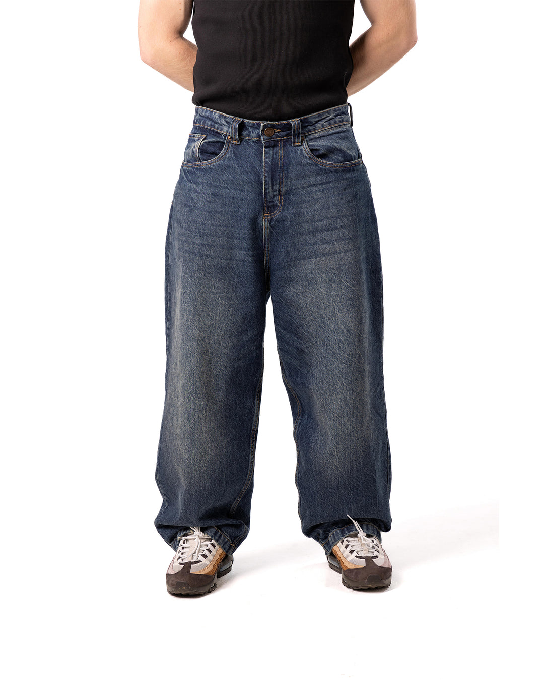 Person wearing wide-leg jeans on a white background