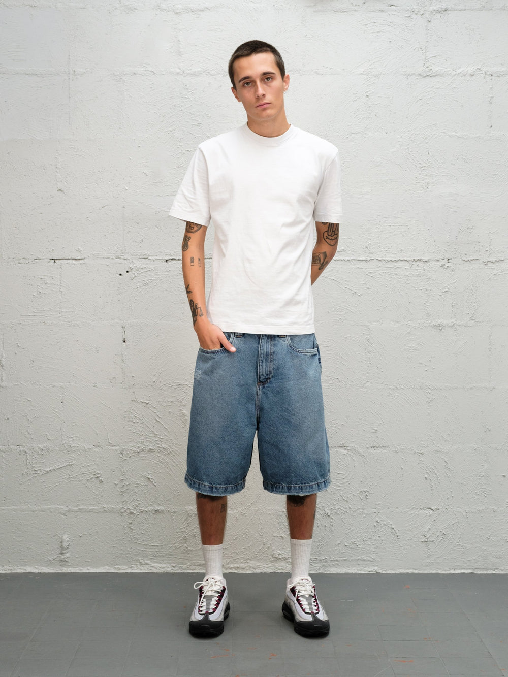 Model wearin Denim Short | Fray paired with 95's and a white t-shirt