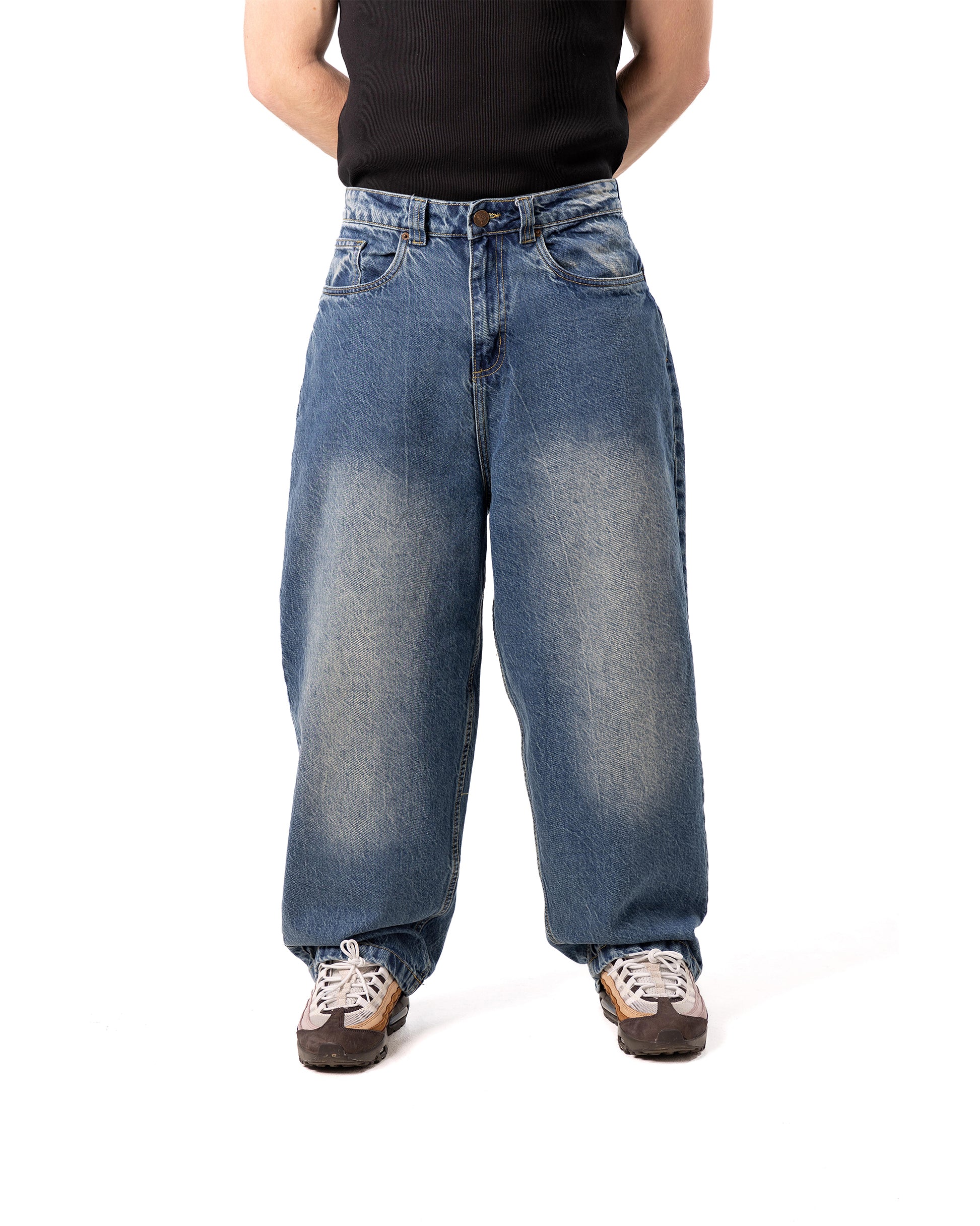 Person wearing blue baggy jeans on a white background