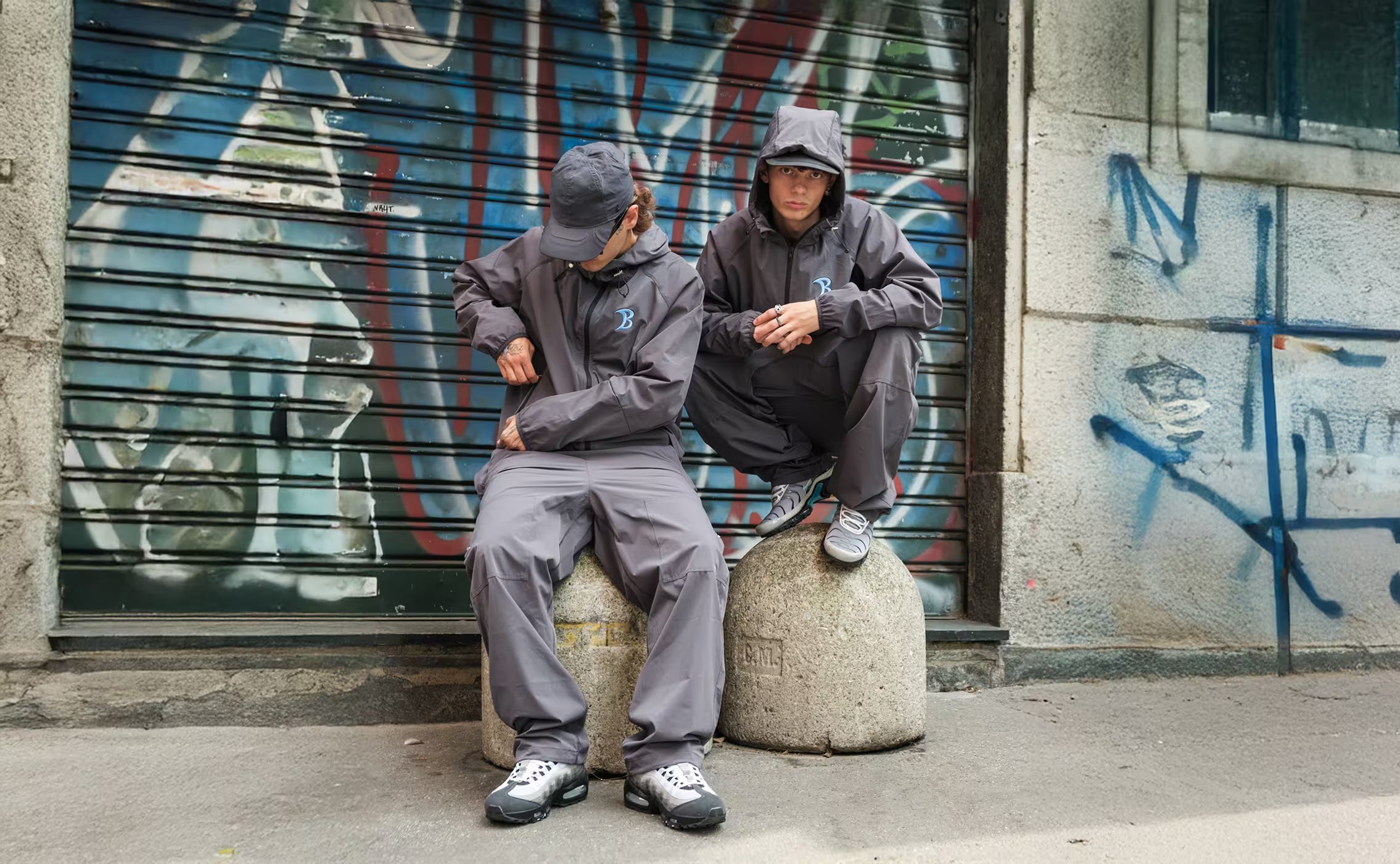 two men wearing baggys vanta tracksuits with air max 95